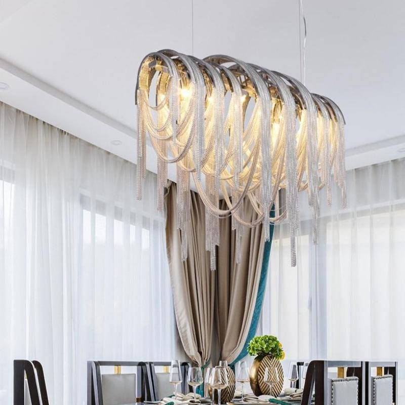 The Cadena tassel dining chandelier by Morsale.com illuminated over a long table, modern aluminum cascade.