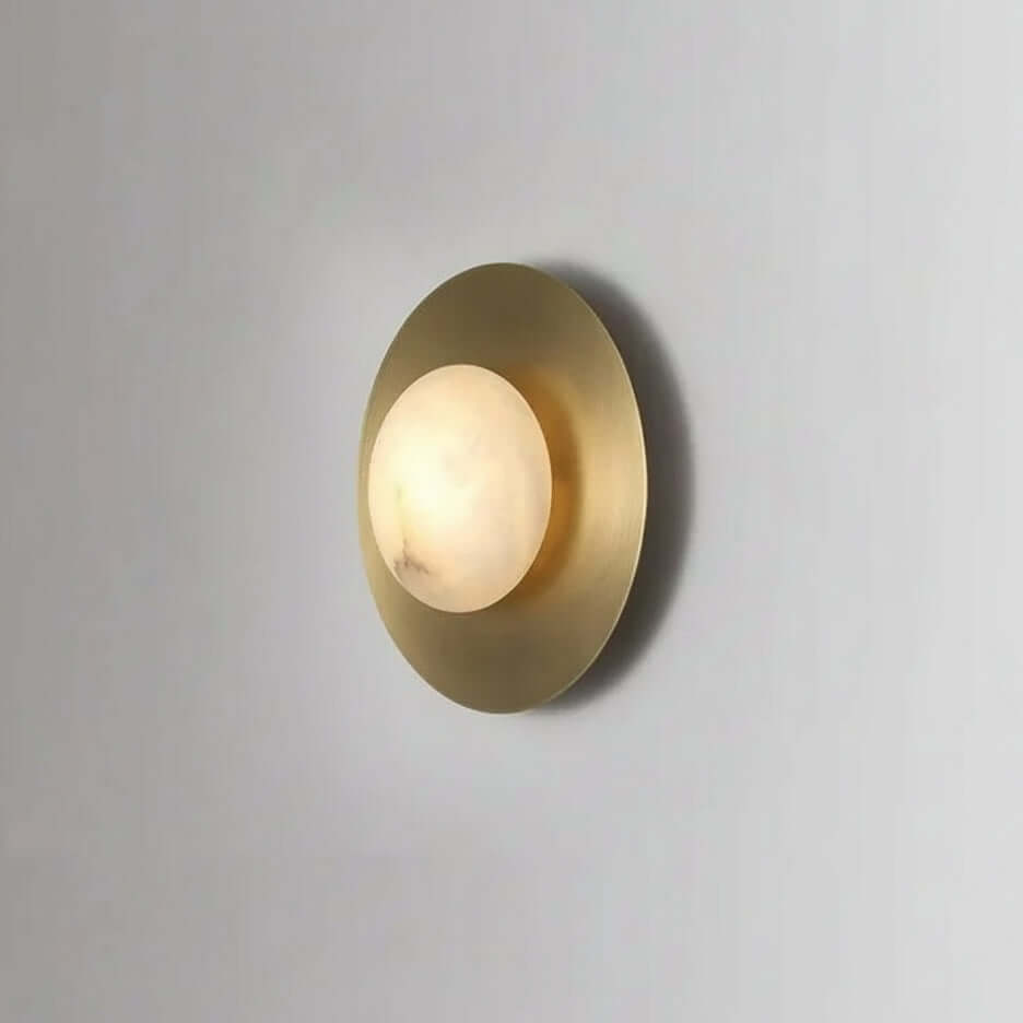 Calla marble and brass wall sconce mounted on a wall