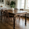Wooden dining table with chairs in a well-lit room
