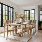 Dining room with wooden table and chairs in a bright room with large windows.