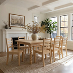 Dining room with wooden table and chairs, fireplace, and large windows.