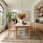 Dining room with wooden table and chairs, floral arrangement, and large windows.
