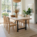 Dining room with wooden table and chairs, large windows, and decorative elements.