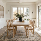 Dining room with wooden table and chairs, large windows, and decorative elements.