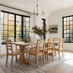 Dining room with wooden table and chairs, large windows, and a chandelier.