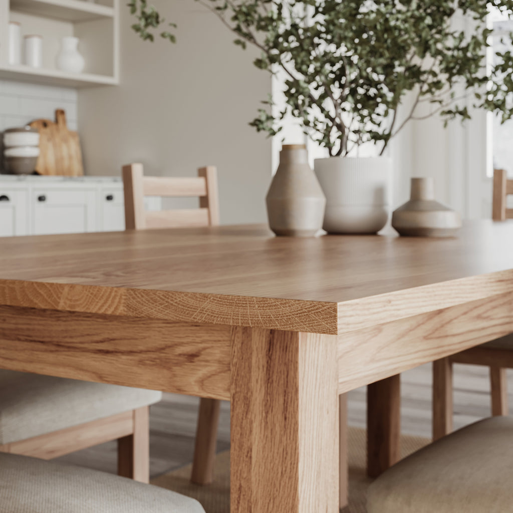 close up image of the corner of an oak dining table with matching chairs