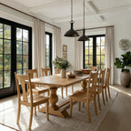 Dining room with wooden table and chairs, large windows, and decorative elements.