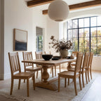 Dining room with wooden table and chairs, large window, and decorative elements.