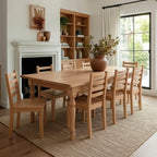 Dining room with wooden table and chairs, fireplace, and large window.