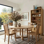 Dining room with wooden table and chairs, modern light fixture, and large plant on the table