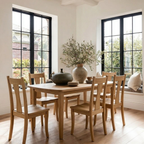 Dining room with wooden table and chairs, large windows, and decorative elements.