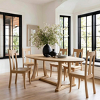 Dining room with wooden table and chairs, large windows, and decorative vase with flowers.