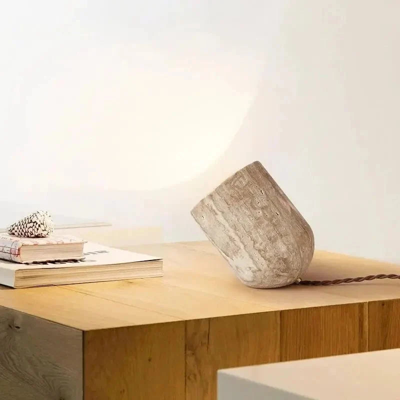 Travertine table lamp casting an upward ambient glow