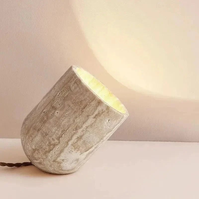 Modern travertine table lamp on a console with a warm glow