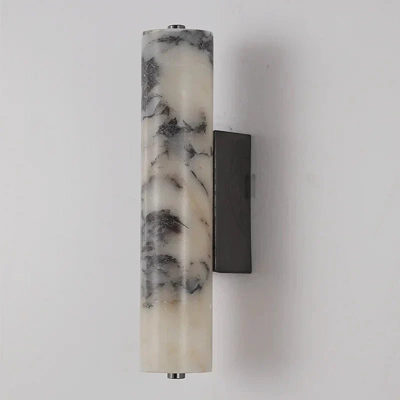 Valmont marble cylinder wall sconce mounted on a wall