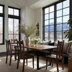 Dining room with wooden table and chairs, large windows, and mountain view.