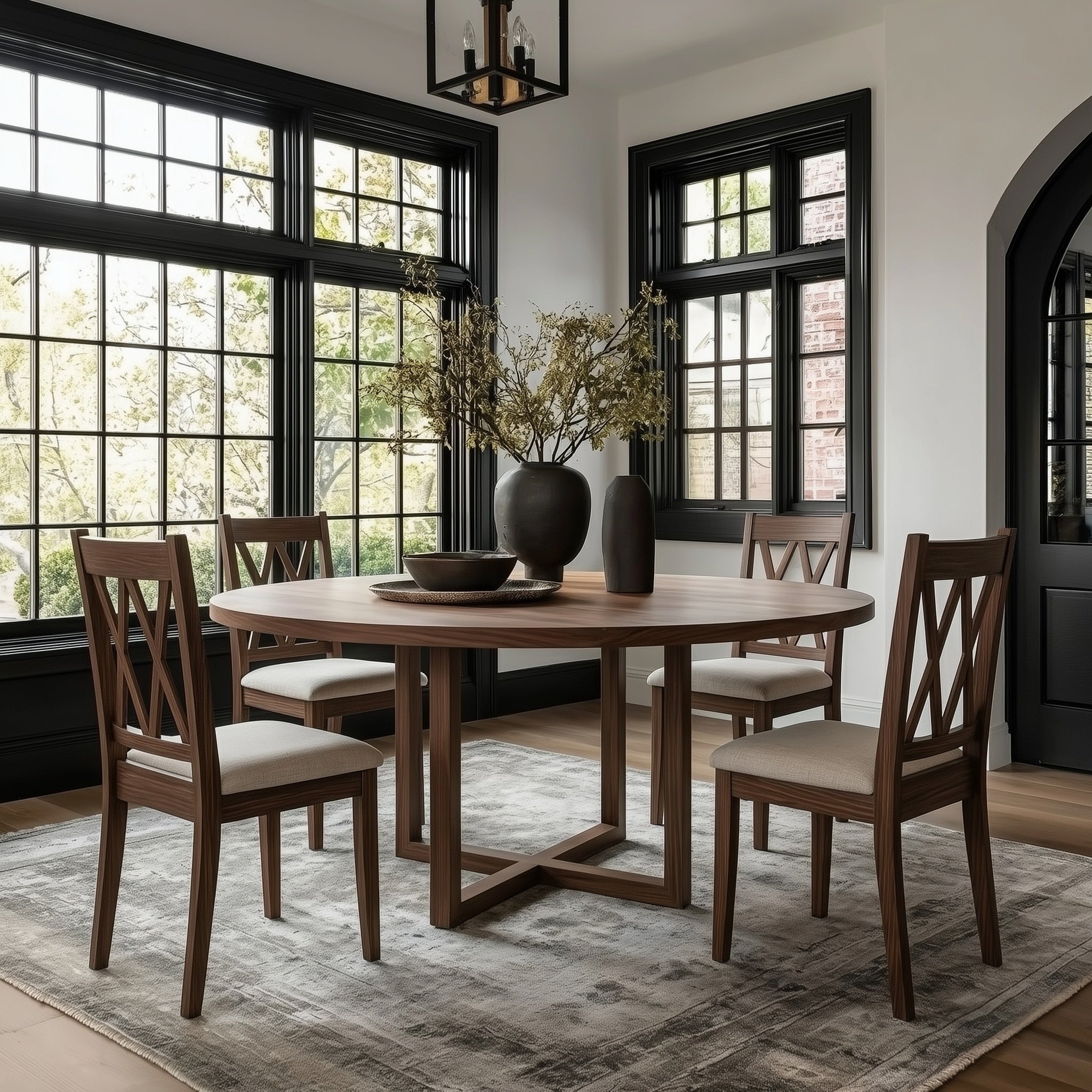 Dining room with wooden table and chairs, modern light fixture, and large plant on the table