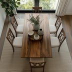 Dining room with wooden table and chairs, plants, and decor.