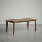 walnut dining table in a large empty space