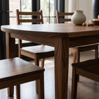 Dining room with wooden table and chairs, large windows, and decorative elements.