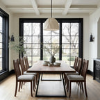 Dining room with wooden table and chairs in a well-lit room with large windows.