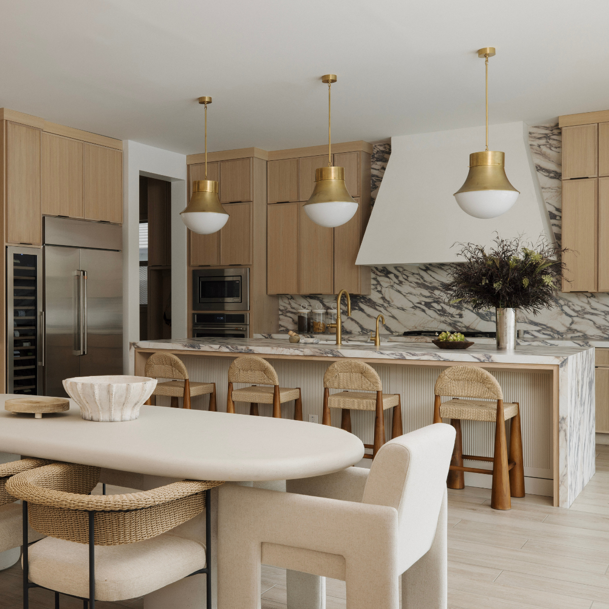 Modern kitchen with marble countertops, wooden cabinets, and pendant lights.