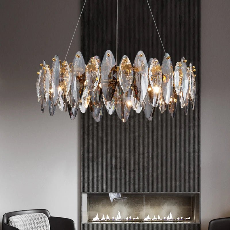 Lazzo modern chandelier with leaf-shaped crystals on a polished gold frame in a dining room