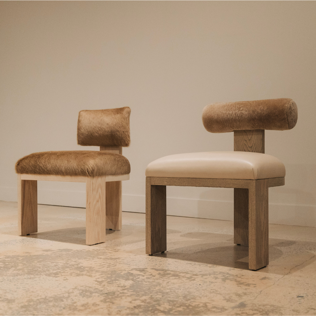 Two modern chairs with brown leather seats and wooden frames on a neutral background