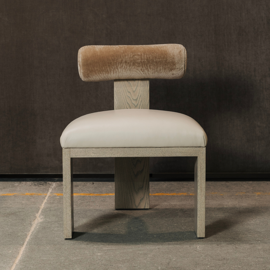 Chair with beige Cylindrical bolster backrest and seat on a dark floor and wall background
