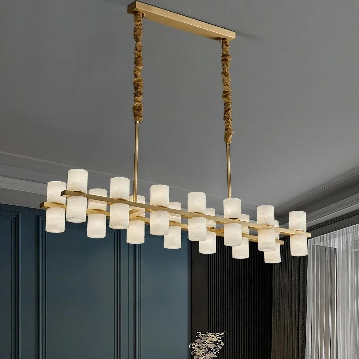Lunara marble chandelier casting up and down light above an island