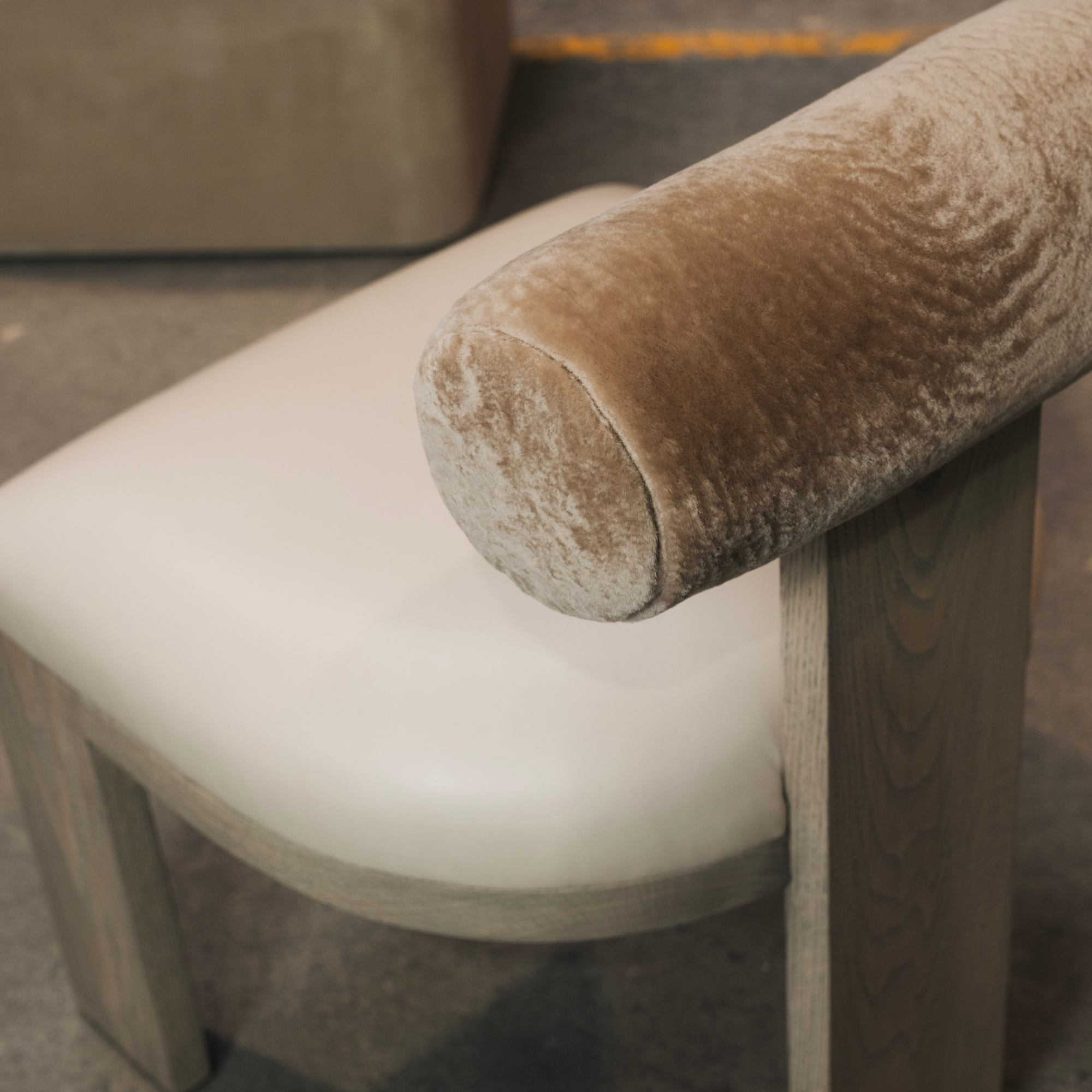 Close-up of a dining chair with a Cylindrical bolster backrest and leather seat.