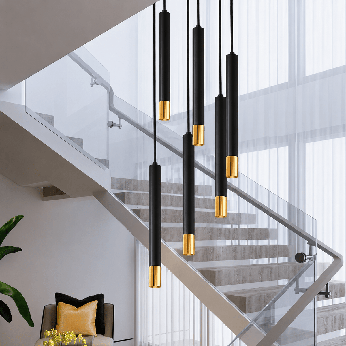 Linea black and gold LED tube chandelier over a modern staircase