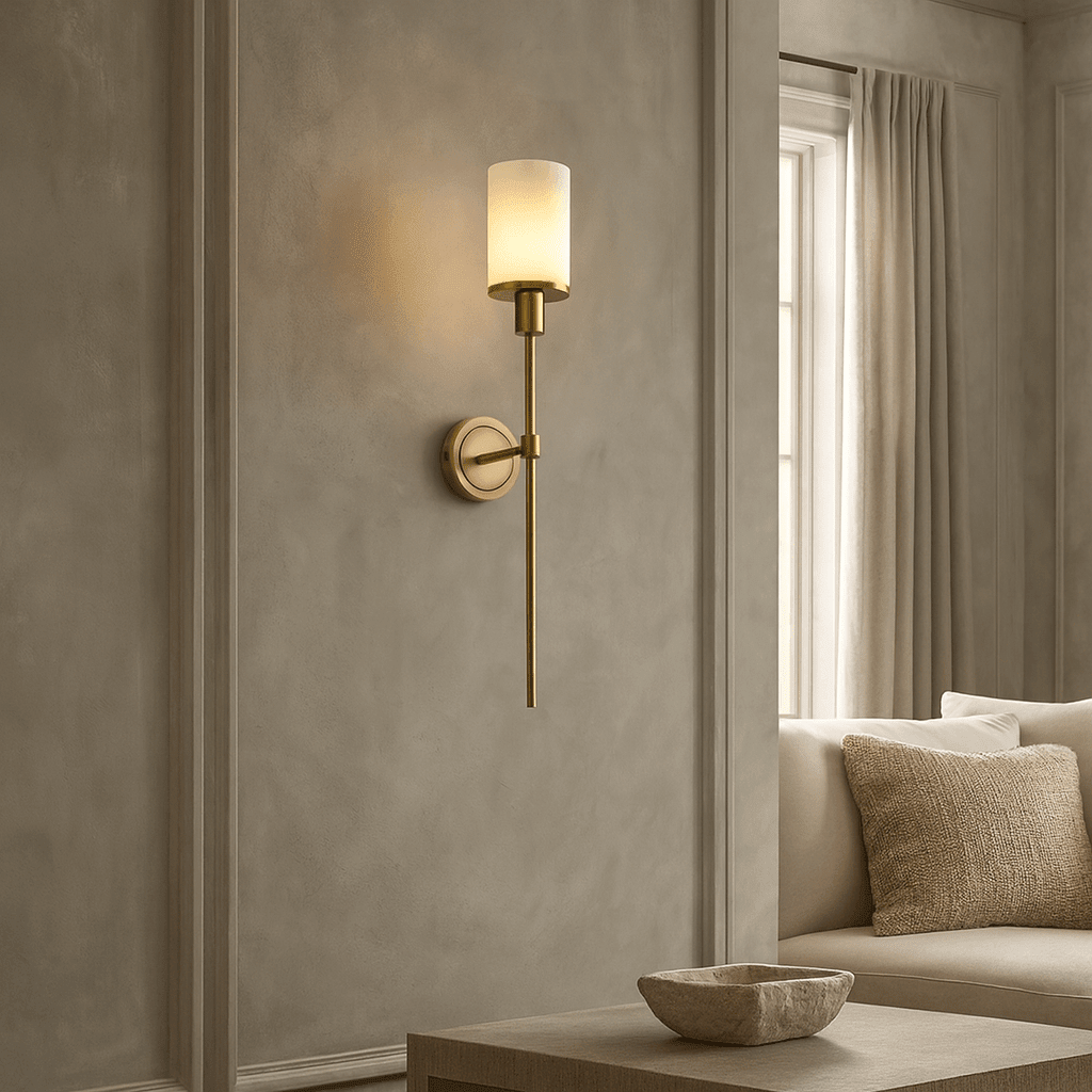 Caldera sconce with glowing marble shade on a brass arm
