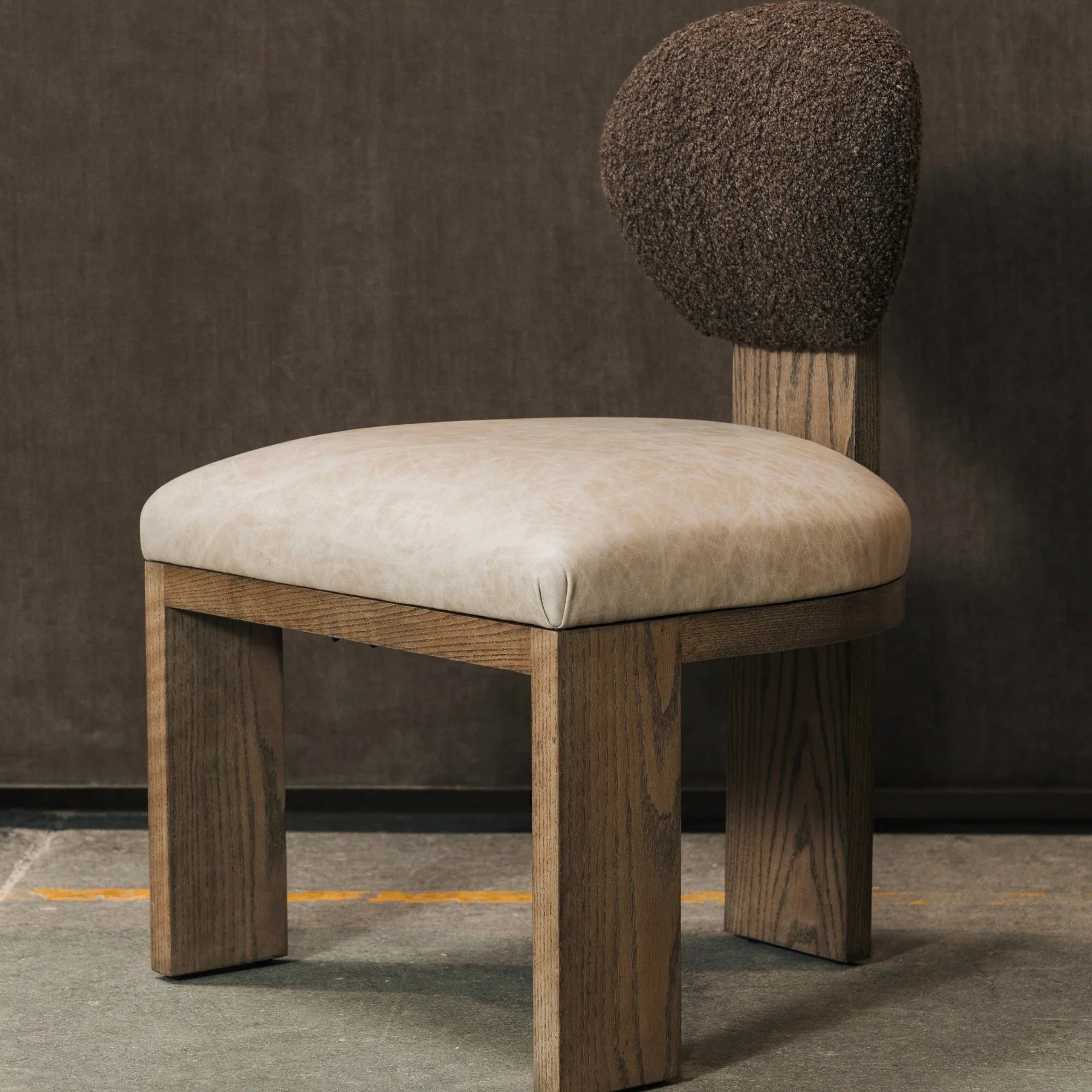 Chair with a boucle backrest and beige leather on a dark background